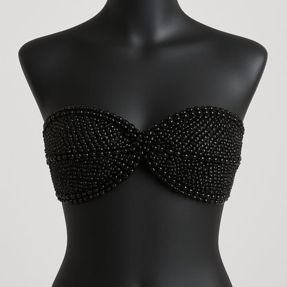 Black beaded strapless top on a mannequin against a plain background
