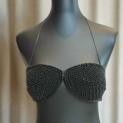 Black beaded bra on a mannequin against a neutral background