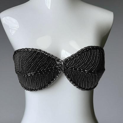 Black beaded strapless top on a mannequin against a gray background